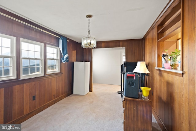 interior space featuring a wealth of natural light, a notable chandelier, and wood walls