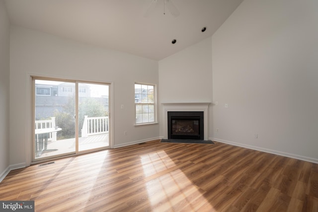 unfurnished living room with hardwood / wood-style floors, high vaulted ceiling, and ceiling fan