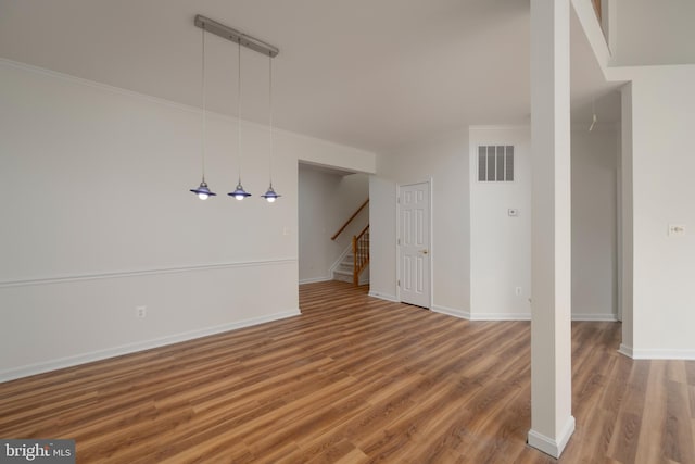 unfurnished living room featuring hardwood / wood-style floors and ornamental molding