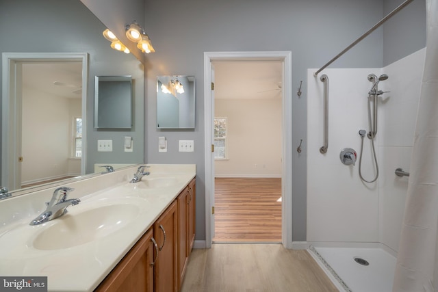 bathroom featuring a tile shower, vanity, and hardwood / wood-style flooring