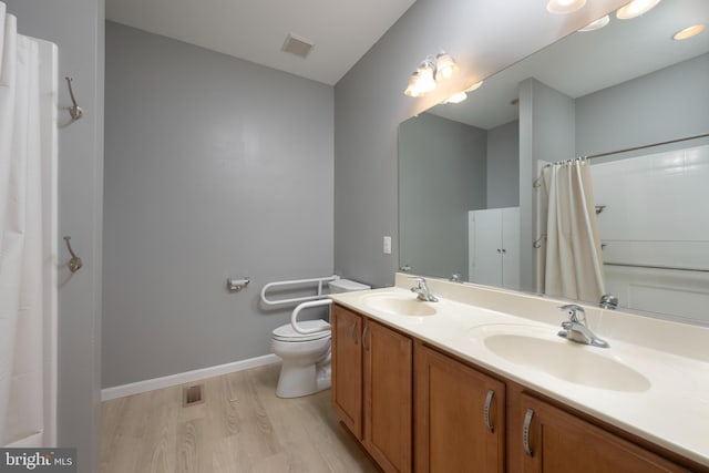 bathroom with curtained shower, vanity, wood-type flooring, and toilet