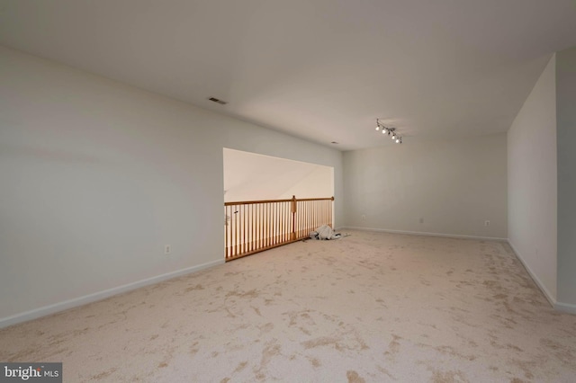 carpeted empty room with track lighting