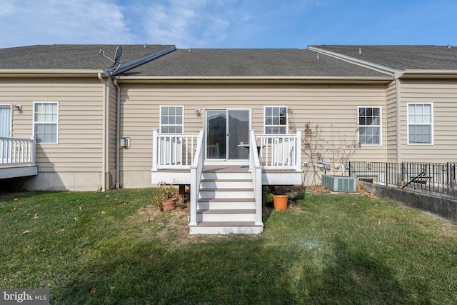 rear view of property featuring a deck, a yard, and central air condition unit