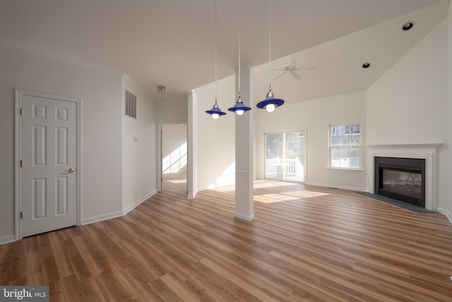 unfurnished living room with hardwood / wood-style flooring, ceiling fan, and high vaulted ceiling