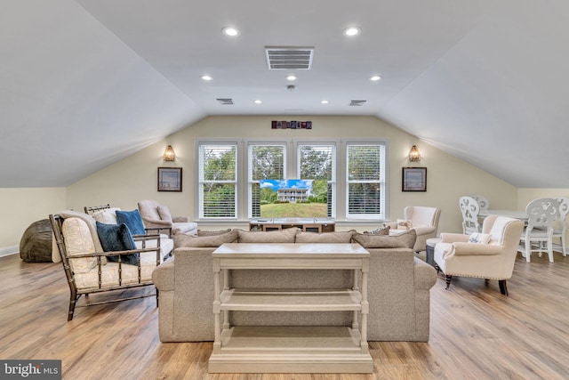 living room with light hardwood / wood-style floors and vaulted ceiling