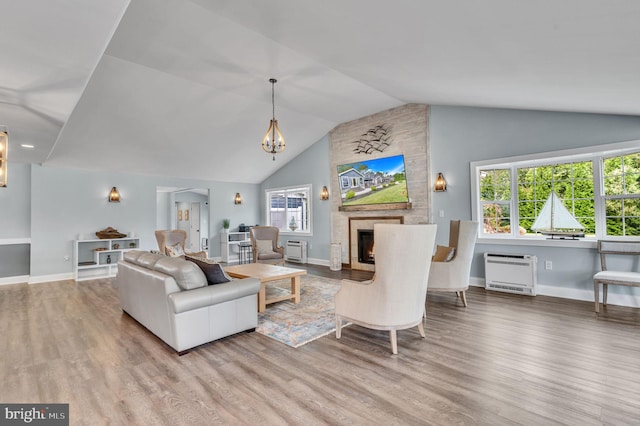 living room with a large fireplace, heating unit, hardwood / wood-style floors, and lofted ceiling