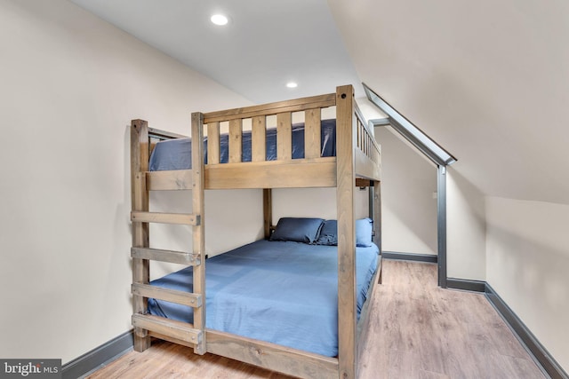 unfurnished bedroom with wood-type flooring and vaulted ceiling