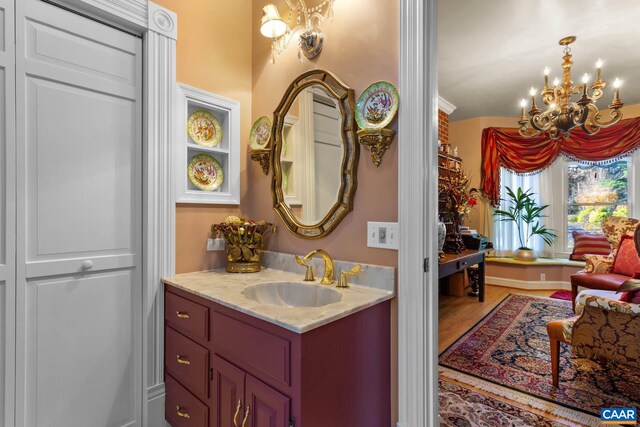 bathroom with vanity, hardwood / wood-style flooring, and a notable chandelier