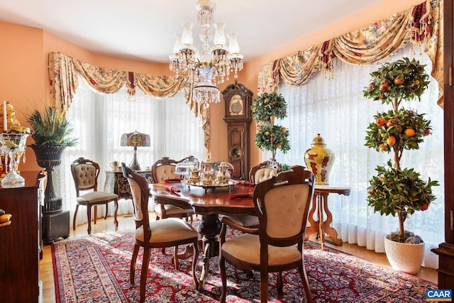 dining space featuring wood-type flooring and an inviting chandelier