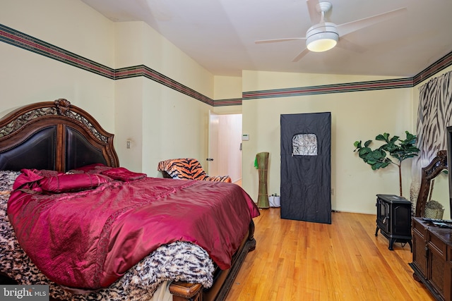 bedroom featuring ceiling fan, light wood-type flooring, and vaulted ceiling