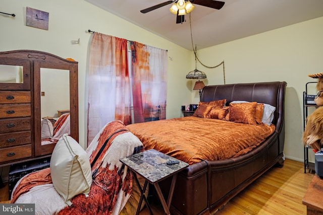 bedroom featuring ceiling fan, light hardwood / wood-style flooring, and lofted ceiling