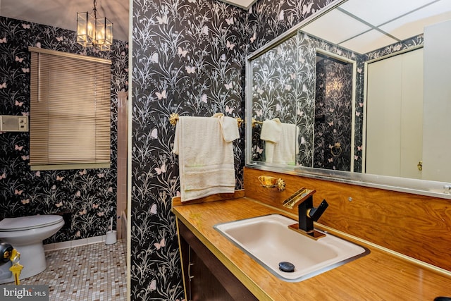 bathroom featuring tile patterned flooring, vanity, toilet, and an inviting chandelier