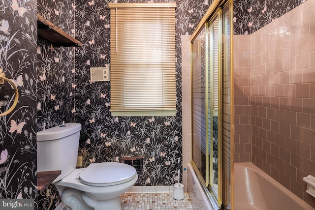 bathroom with tile patterned floors, toilet, and a shower with shower door