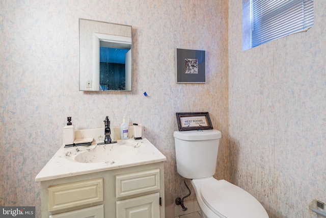 bathroom with tile patterned flooring, vanity, and toilet