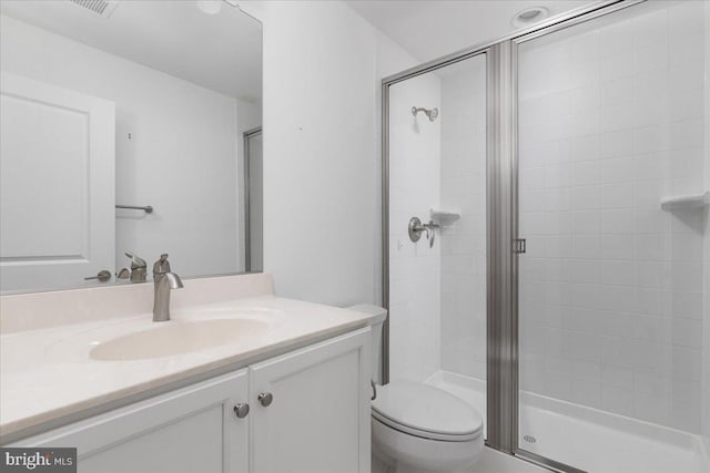 bathroom with vanity, a shower with shower door, and toilet