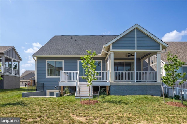 rear view of property with a yard, ceiling fan, and a sunroom