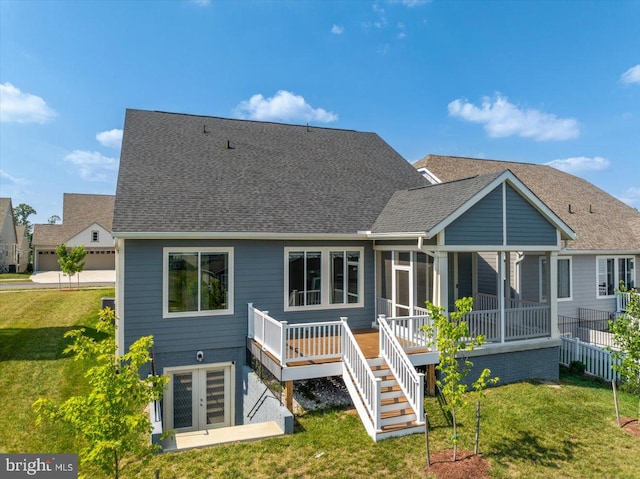 rear view of house with a sunroom, a yard, and a deck