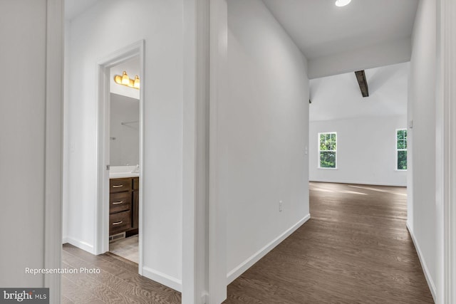 hallway featuring dark hardwood / wood-style flooring and lofted ceiling with beams