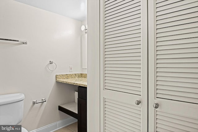 bathroom with tile patterned flooring, vanity, and toilet