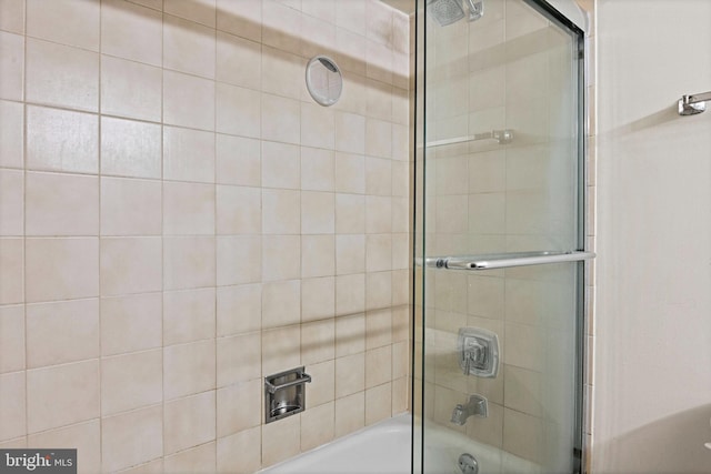 bathroom with bath / shower combo with glass door