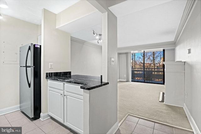 kitchen with light carpet, white cabinets, stainless steel refrigerator, and ornamental molding