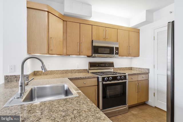 kitchen featuring sink, light tile patterned floors, stainless steel appliances, and light brown cabinets