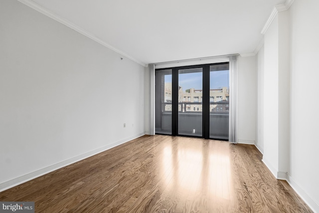 spare room with crown molding and light wood-type flooring