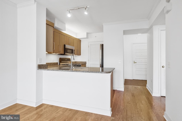 kitchen featuring crown molding, sink, stainless steel appliances, and light wood-type flooring