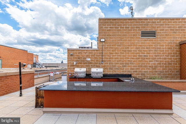 view of patio featuring a grill, exterior kitchen, and sink