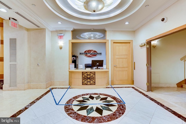 tiled entryway featuring a raised ceiling and ornamental molding