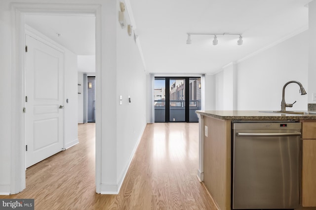 kitchen with stainless steel dishwasher, crown molding, sink, and light hardwood / wood-style flooring