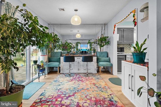 interior space featuring a textured ceiling and light hardwood / wood-style floors