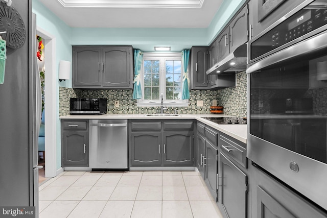 kitchen with gray cabinetry, sink, appliances with stainless steel finishes, tasteful backsplash, and light tile patterned flooring