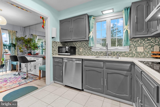 kitchen with ventilation hood, sink, decorative backsplash, gray cabinets, and appliances with stainless steel finishes