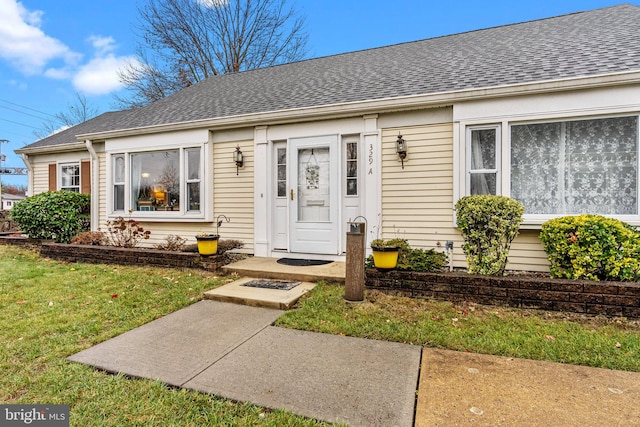 entrance to property featuring a lawn