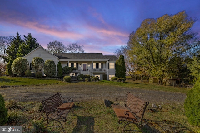 view of front of house with covered porch and a yard