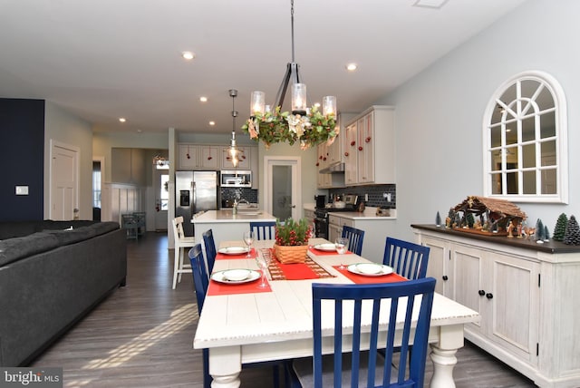 dining room featuring dark hardwood / wood-style flooring, sink, and a chandelier