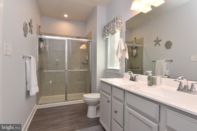 bathroom with vanity, hardwood / wood-style flooring, toilet, and a shower with shower door