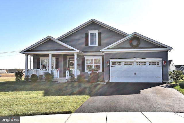 view of front facade with a front lawn, covered porch, and a garage