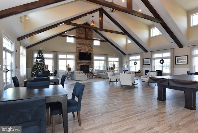 dining space with a wealth of natural light, high vaulted ceiling, and light hardwood / wood-style floors