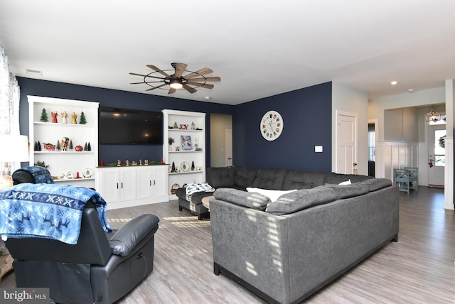 living room with ceiling fan and light hardwood / wood-style flooring