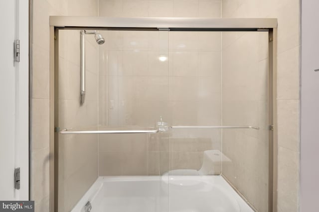 bathroom with shower / bath combination with glass door