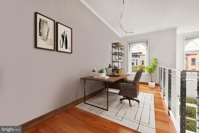 home office with light hardwood / wood-style floors and ornamental molding