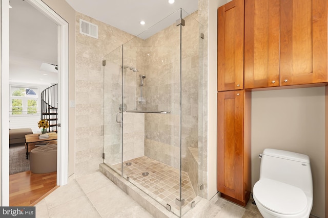 bathroom featuring hardwood / wood-style floors, toilet, and an enclosed shower