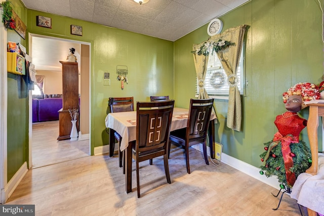 dining space featuring baseboards and wood finished floors