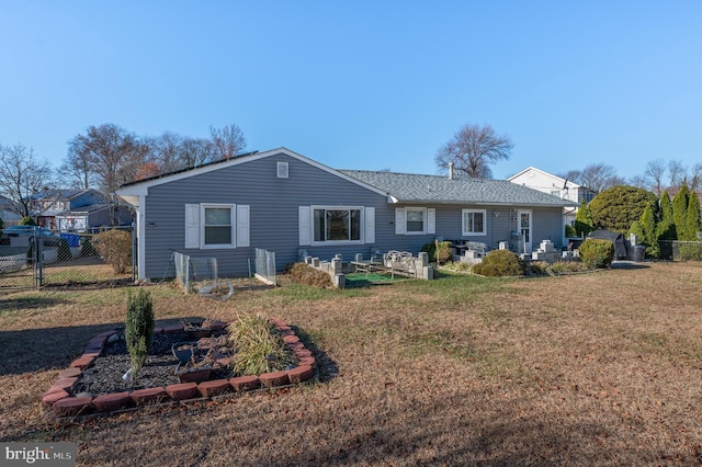 view of front of house featuring a front lawn, fence, and a vegetable garden