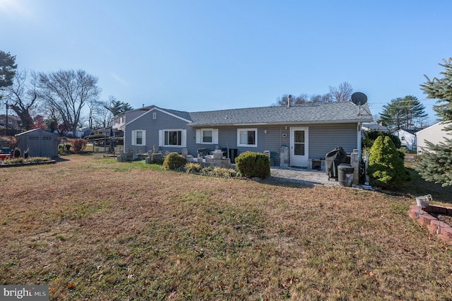 view of front of property featuring an outbuilding, a patio, a front lawn, and a shed