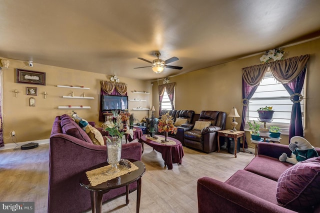 living room with baseboards, ceiling fan, and light wood finished floors