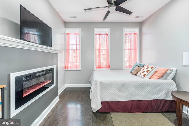 bedroom with ceiling fan and dark hardwood / wood-style flooring