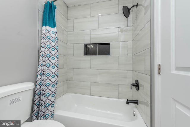 bathroom featuring shower / bathtub combination with curtain and toilet